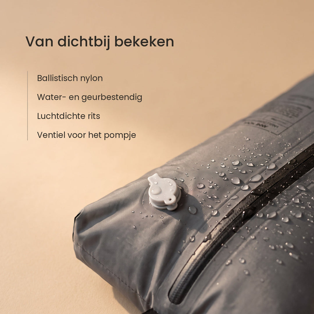 Close-up van de Nomadic compressiezak met het ventiel, de luchtdichte rits en waterdruppels op het nylon